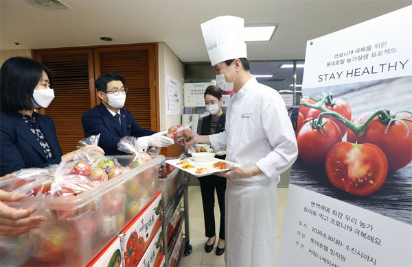 롯데호텔 직원들이 강원도 춘천 지역 농가에서 생산된 토마토를 수령하고 있다. 롯데호텔은 토마토 1만t을 구매해 임직원들에게 전달했다. [사진 제공 = 롯데호텔]